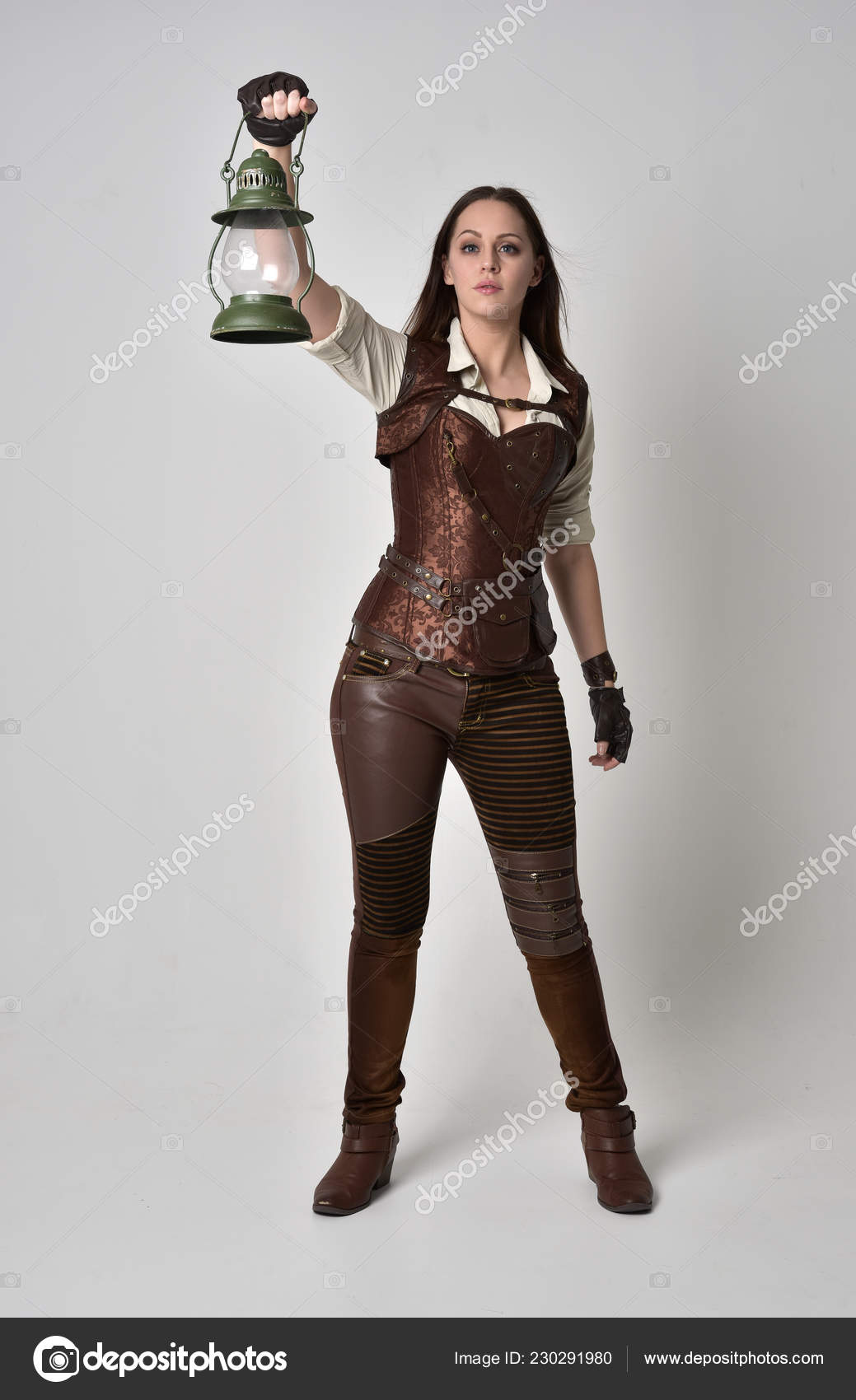 Stock photo of a woman in a leather costume holding a green lantern overhead