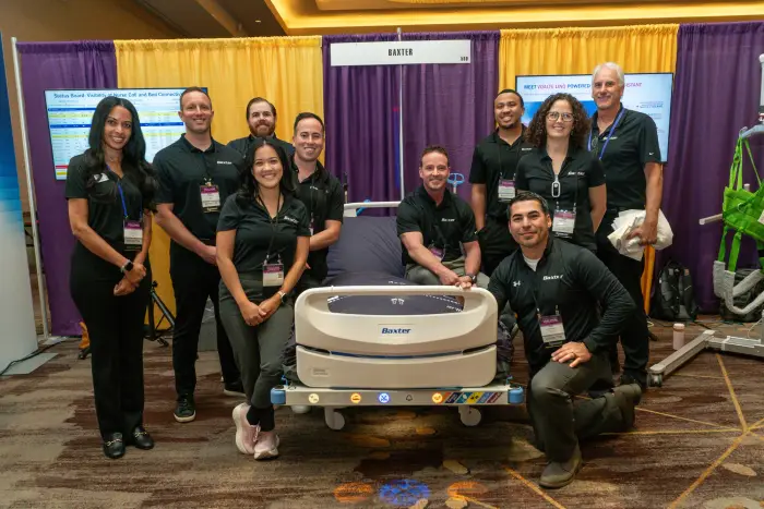 A vendor team in matching black polos posing with their equipment at a booth