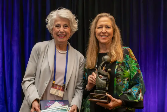 Two nurse leaders posing, one holding a bronze award