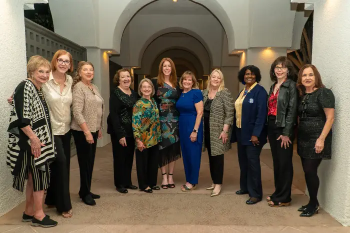 A group of nurse leaders posing together for a portrait in a hall